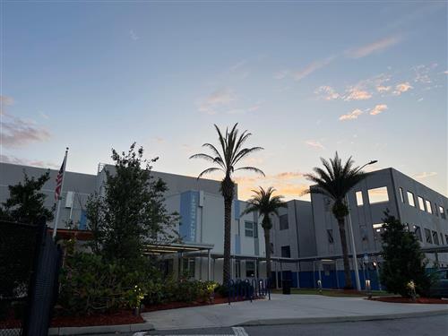 A photo of NeoCity Academy taken at sunrise, showing the concrete framework of the new building.