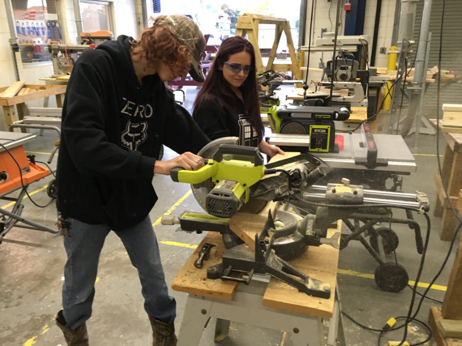 Students working with wood on a skill saw.